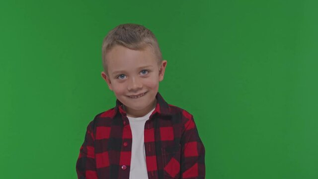 Close up shot of cute little boy shakes his head in agreement 