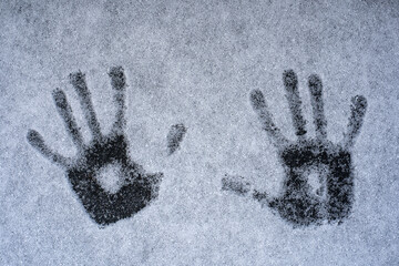 Photograph of the prints of two palms in the snow. Footprints in the snow.