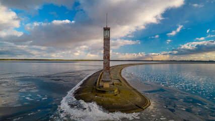 Aerial view of a pier with a lighthouse on a frozen lake