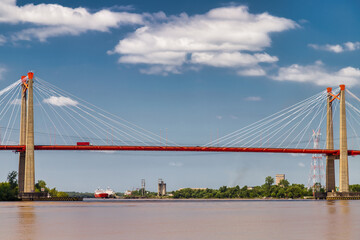 Fototapeta na wymiar Zarate suspension bridge (Argentina) with cargo ships in the background