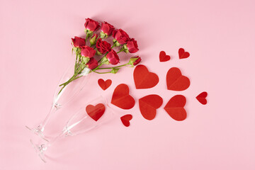 Hearts greeting cards, red roses and glasses on a pink background