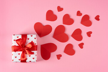 Valentine's Day celebration. Gift box with hearts cards on a pink background.