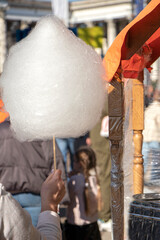 Street sweets. buying cotton candy at a street fair. young woman holds cotton candy in her hand and walks. back. High quality photo