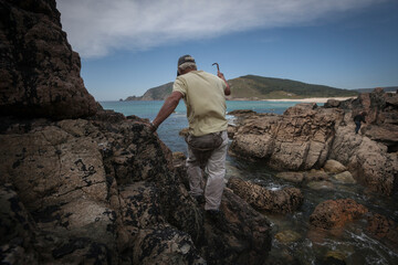 Obraz premium A barn owl searches for barnacles on the rocks off the coast of Finisterre