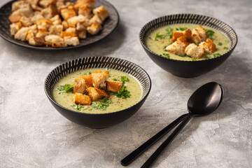 Homemade broccoli cream soup on light background.