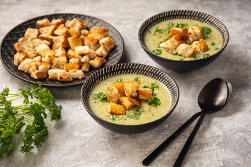 Homemade broccoli cream soup on light background.