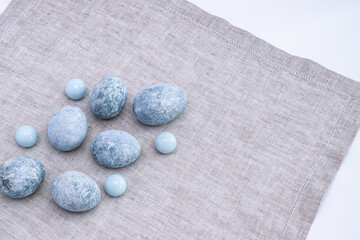 Marble Easter eggs on a gray linen napkin. Easter greeting card.