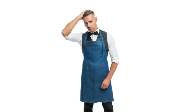 Serious man in bow and bartender apron fixing hair isolated on white, barkeeper