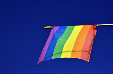 Regenbogenflagge vor blauem Himmel