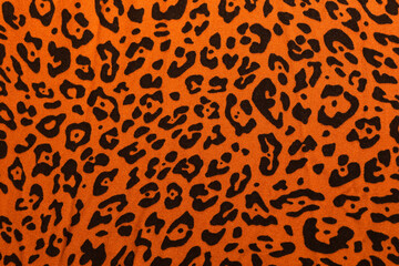 Cotton fabric with leopard print. Orange with black spots. Material for the dress.