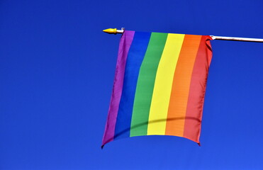 Regenbogenflagge vor blauem Himmel