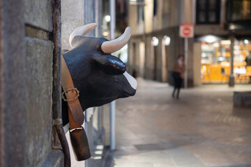 Milk cow sculpture looks at a person strolling at night on a lonely street