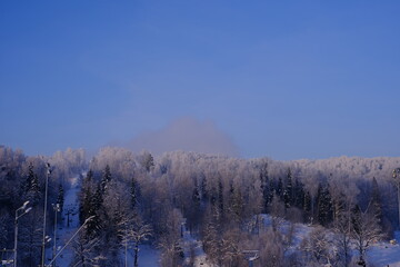 Snow-covered trees in hoarfrost at a ski resort, lift, funicular, ski lift