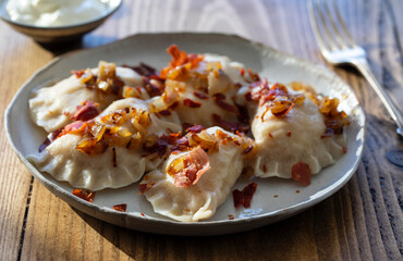 Traditional polish dumplings, pierogi, with fried onion and bacon