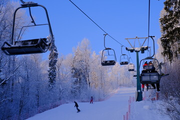 Fototapeta na wymiar Snow-covered trees in hoarfrost at a ski resort, lift, funicular, ski lift