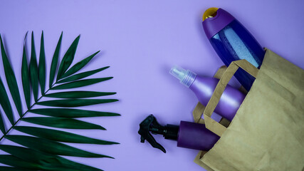 Lilac, purple cosmetic dispenser bottle mockup with palm leaves.Product branding, spa, beauty background.Cosmetic mock-ups of bottles, tubes. Reusable paper bag with a set of organic natural cosmetics