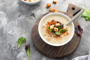 Mushroom cream soup with croutons served on concrete background. Soup in a bowl. Top view  - obrazy, fototapety, plakaty