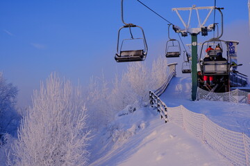 Fototapeta na wymiar Snow-covered trees in hoarfrost at a ski resort, lift, funicular, ski lift