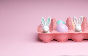 Shot of arrangement decoration Happy Easter holiday on a pink background.Colorful Easter eggs in paper box. Copy space.