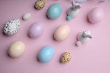 Fototapeta na wymiar Colored easter eggs with a deco bunny on a pink background. Festive spring decoration , pastel colors .