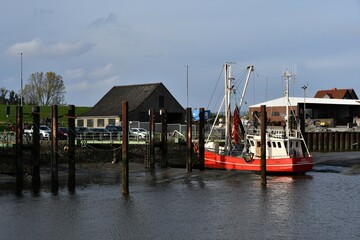 Fototapeta na wymiar Fischkutter bei Ebbe im Hafen von Fedderwardersiel / Butjadingen