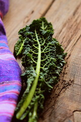 Vertical photo of a green cabbage leaf on a wooden background selective focus. Healthy detox...