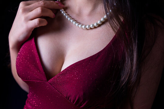 bust of the chest of a girl in a beautiful burgundy evening dress with pearl beads decoration