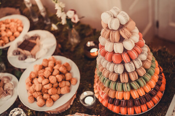 Festive dessert table featuring colorful macaroons, profiteroles, and cake