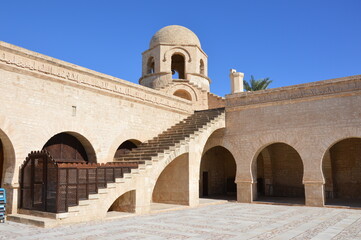 The Great Mosque in Sousse, Tunisia, Africa. Blue sky, ancient stone arces, stairway and corner tower