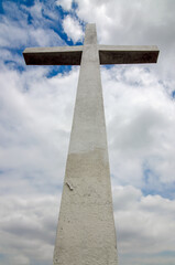 A stone cross beneath a cloudy sky.