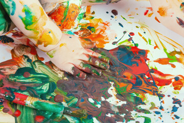 Toddler spilled paint. The child's hand is smeared with paint.