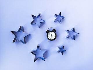 Obraz premium The concept of sleep. Night sky with purple background, stars and alarm clock
