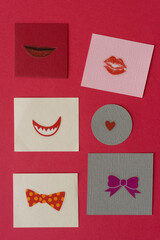 stickers of lips, hearts, and bow ties on red