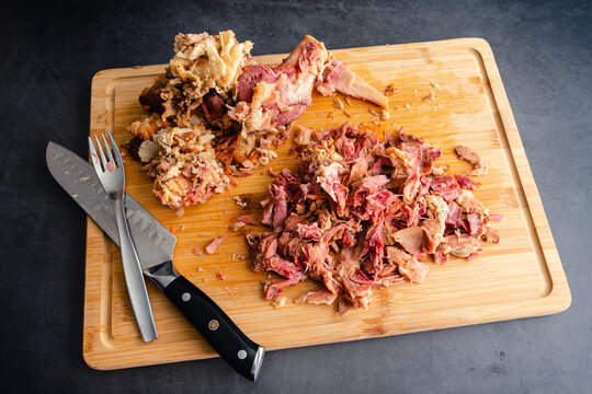 Removing Meat from a Boiled Ham Bone: Using a chef's knife and fork to remove the meat from a hambone