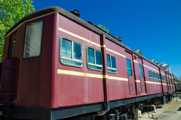Fototapeta na wymiar The Vintage train in Maroon color with daylight blue sky in the background.