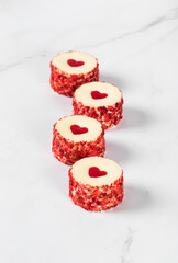 Sweet festive round sushi with jelly in the shape of a heart, sprinkled with small pieces of freeze-dried strawberries on a white background. Valentine's Day