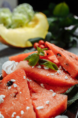 Pieces of fresh red watermelon on a black plate