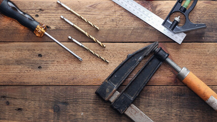 Collection of woodworking tools on a wooden background.