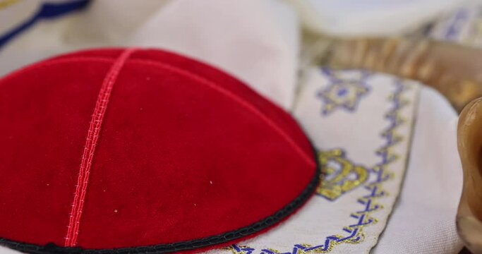 Jewish Orthodox prayer items kippa on shofar, torah scroll in a synagogue