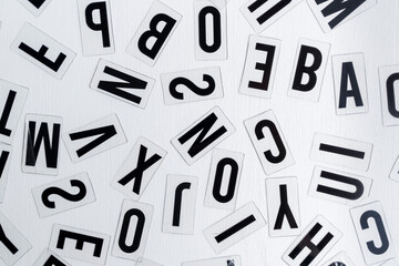 letras 2D de plástico aleatorias para letrero luminoso sobre fondo blanco de madera vista cenital,