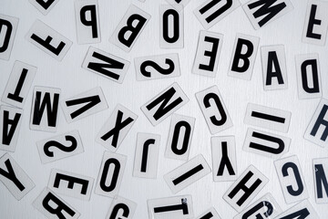 letras 2D de plástico aleatorias para letrero luminoso sobre fondo blanco de madera vista cenital,