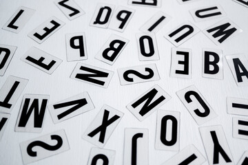 letras 2D de plástico aleatorias para letrero luminoso sobre fondo blanco de madera vista cenital,