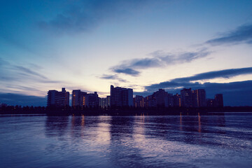 夜明け前の都市景観。太陽が昇前のマジックアワー。あたりがオレンジ色に染まる。兵庫県芦屋浜より西宮浜を臨む