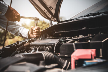 Car care maintenance and servicing, Close-up hand technician auto mechanic using the wrench to repairing change spare part car engine problem and car insurance service support.