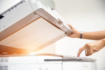 Copier printer, Close up hand office man press copy button on panel to using the copier or photocopier machine for scanning document printing a sheet paper and xerox photocopy. - obrazy, fototapety, plakaty
