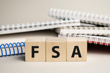 Flexible Spending Account FSA on wooden table over light blue gradient background, Frequently asked...