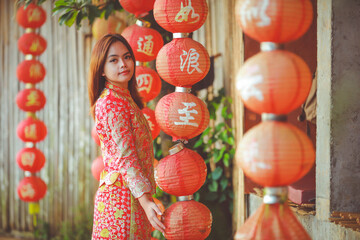 Beautiful Asian Chinese Woman Wearing Cheongsam Traditional Red Dress on Chinese New Year travel on vacation Posting on a boat in the river.