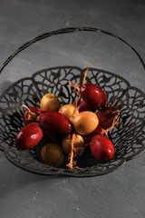 Red and Yellow Raw Dates Fruit or Kurma Muda (Ruthob) on Vintage Basket Above Rustic Background. COpy Space for Text