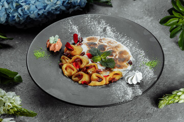 Pancakes with cheese in orange sauce served with caramelized nuts and almonds. Appetizing dish. Culinary photography, a proposal to serve a meal