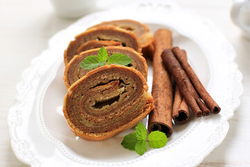 Small Mini Lapis Legit Roll, Delicious Traditional Cake from Indonesia with Spice and Cinnamon. White Background and White Plate